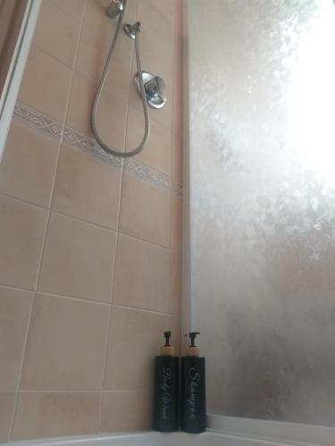 a shower with two black bottles in a bathroom at Mosci's Bed & Beer in San Damiano dʼAsti