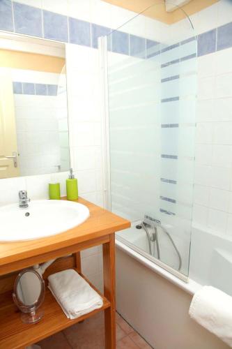 une salle de bain avec un lavabo, une douche et une baignoire dans l'établissement Résidence Néméa les Portes des Cévennes, à Sauve