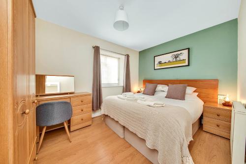 ein Schlafzimmer mit einem Bett, einem Schreibtisch und einem Fernseher in der Unterkunft Finest Retreats - Rosedale Hall Cottage in Thirsk