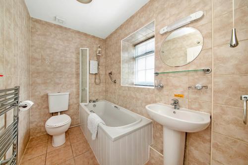 a bathroom with a sink toilet and a mirror at Finest Retreats - Rosedale Hall Cottage in Thirsk