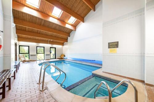 une piscine dans un bâtiment avec une piscine intérieure dans l'établissement Finest Retreats - Roulston Hall Apt, à Thirsk