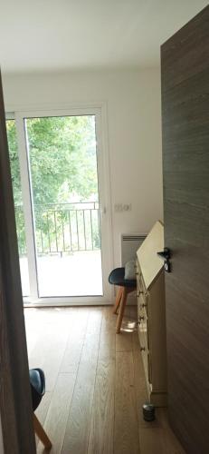 une pièce avec un bureau et une grande fenêtre dans l'établissement Au coin du potager, à Le Rouret