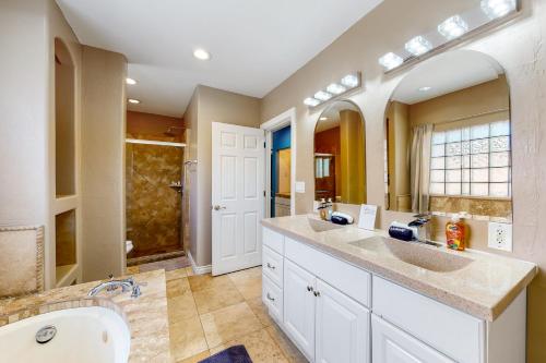 a bathroom with two sinks and a large mirror at Desert Haven Hideaway in Phoenix