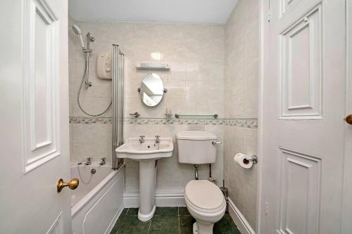 a white bathroom with a toilet and a sink at Finest Retreats - York Hall Apt in Thirsk