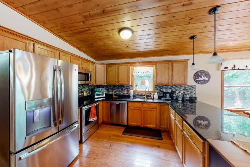 a kitchen with a stainless steel refrigerator and wooden cabinets at Whistle and Quill Lodge in Swanton