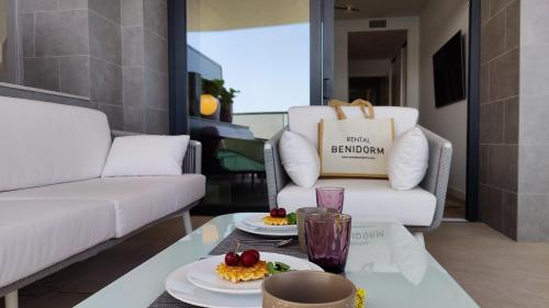 een woonkamer met een tafel met twee borden eten bij SUNSET CLIFFS modern apartment in Benidorm