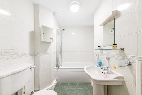 Baño blanco con lavabo y aseo en Finest Retreats - Sutton Hall Apt, en Thirsk