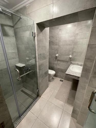 uma casa de banho com um chuveiro, um WC e um lavatório. em Miramar Evergreen Hotel no Cairo