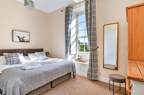 - une chambre avec un grand lit et une fenêtre dans l'établissement Finest Retreats - Sutton Hall Apt, à Thirsk