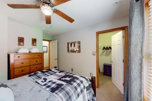 a bedroom with a bed and a ceiling fan at Whistle and Quill Lodge in Swanton