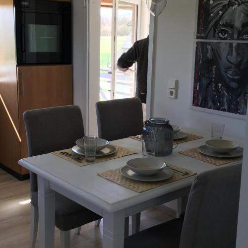 a white table with chairs and plates on it at Ferienwohnung am Klosterforst 