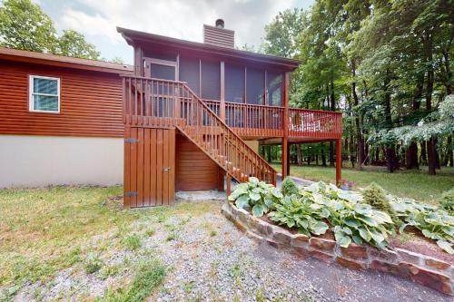 a house with a large deck on the side of it at Whistle and Quill Lodge in Swanton