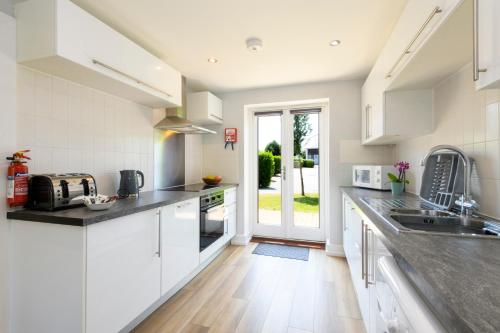a kitchen with white cabinets and a counter top at Bay Retreat Villas in Padstow