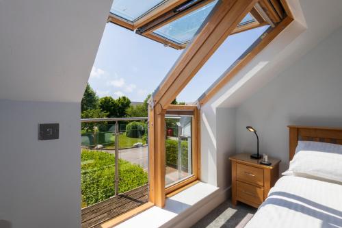 a bedroom with a bed and a window with a view at Bay Retreat Villas in Padstow