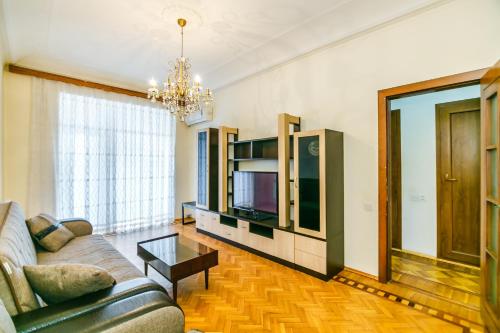 Deluxe Apartment 130 في باكو: غرفة معيشة بها أريكة وتلفزيون