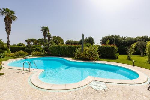 einen Pool in einem Garten mit Bäumen und Sträuchern in der Unterkunft Villa Frida - Piscina privata ed Eventi a Lecce in San Pietro in Lama