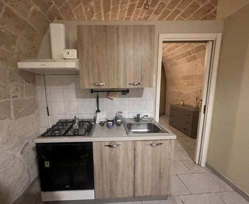 Il comprend une cuisine équipée d'un évier et d'une cuisinière. dans l'établissement futura home centro storico 5 minuti da Bari, à Modugno