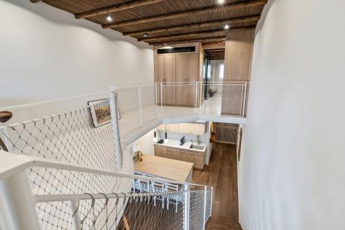 a staircase in a room with white walls and wooden ceilings at Gaudi Beach view in Tel Aviv