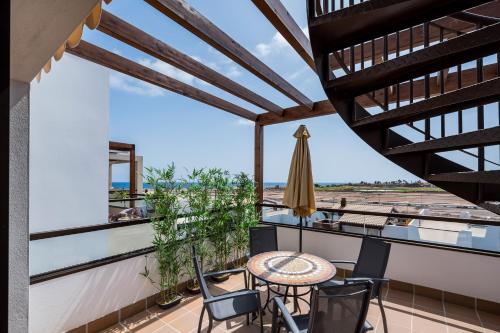 a patio with a table and chairs on a balcony at Casa Albatros - luxuriöses Penthouse-Apartment in Caleta De Fuste
