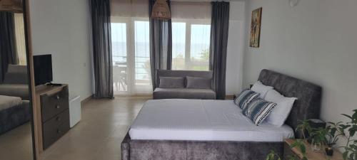 a living room with a bed and a chair at Vila DVG Costinesti in Costinesti