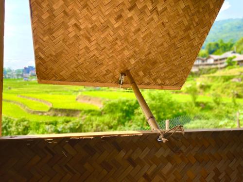 a wooden table with a view of a green field at maison Rose & Jardinier eco homestay in Sa Pa