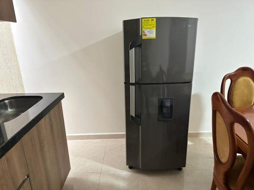 a black refrigerator in a kitchen with a counter at Apto-Parking cerca CC Gran Plaza in Pitalito