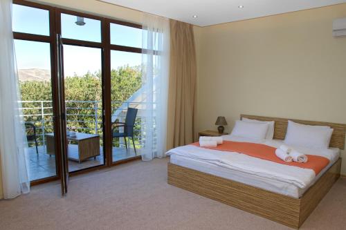 1 dormitorio con 1 cama y balcón en Art Hotel KOKTEBEL APARTMENTS, en Koktebel