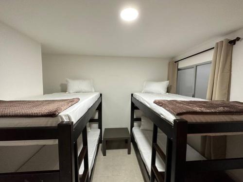 two bunk beds in a room with a window at Apto-Parking cerca CC Gran Plaza in Pitalito