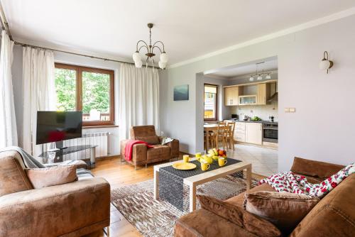 een woonkamer met een bank en een tafel bij Willa Marta Zakopane in Zakopane