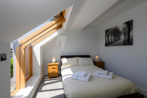 a bedroom with a bed with two towels on it at Bay Retreat Villas in Padstow