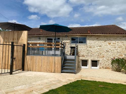 une maison avec une porte en bois et un parasol dans l'établissement Entre ciel et Lot, à Prayssac