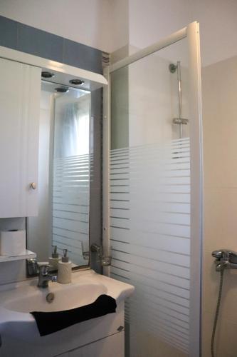 a bathroom with a sink and a shower with a mirror at Ateni House in Agios Petros