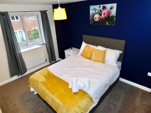 a bedroom with a large bed with a blue wall at AMILA House Manchester, Modern, Spacious, Sleeps 7 With Parking in Manchester