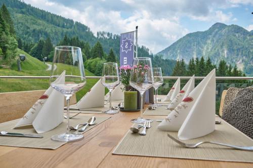 a table with wine glasses and napkins on it at Alpendorf Hotel Stern in Sankt Johann im Pongau