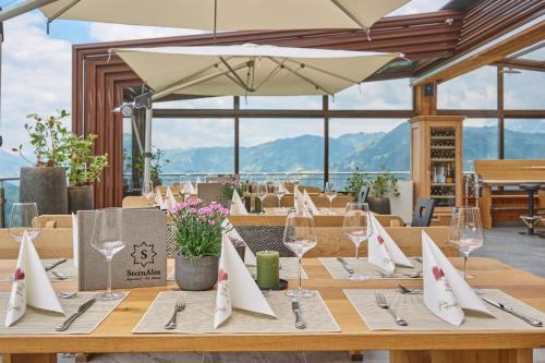 a long wooden table with wine glasses and napkins at Alpendorf Hotel Stern in Sankt Johann im Pongau