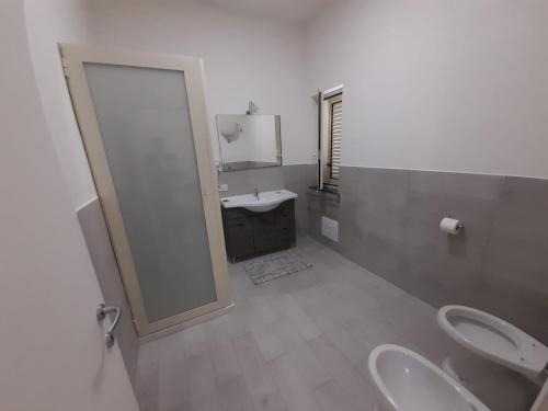 ein Badezimmer mit 2 WCs, einem Waschbecken und einem Spiegel in der Unterkunft Terrazza Passione in Corbara