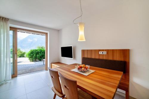 a dining room with a wooden table and a television at Langstein Wohnung Golden in Coldrano