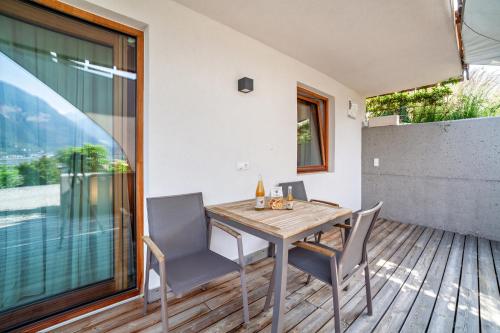 a wooden table and chairs on a wooden deck at Langstein Wohnung Golden in Coldrano