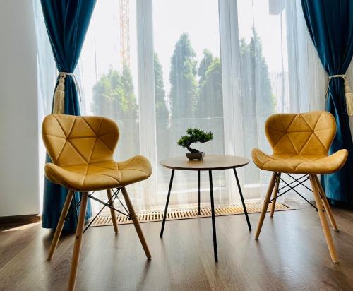 two chairs and a table in front of a window at Aventurescu Studio Brasov Coresi in Braşov