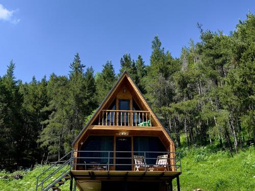 una cabaña en el bosque con terraza y sillas en Sno Woodland, en Sno