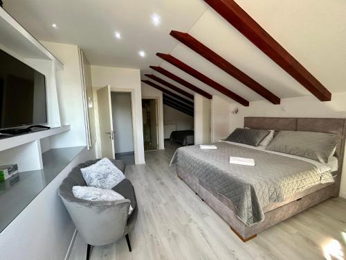 a bedroom with a bed and a couch and a tv at Villa Hera Sevid in Sevid