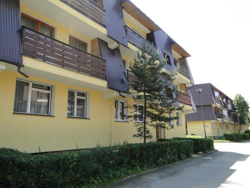 een geel gebouw met een zwart dak bij Apartament Kasprusie 65m2 in Zakopane