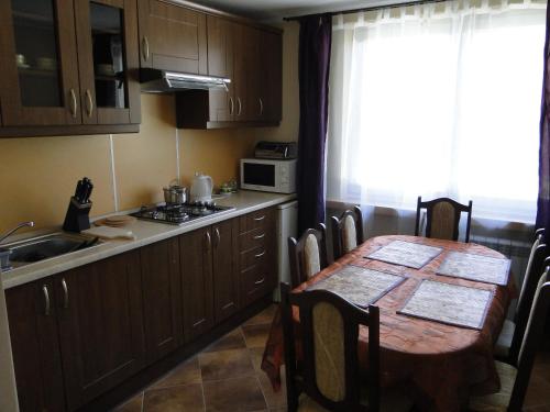 een keuken met een tafel en een wastafel en een tafel en stoelen bij Apartament Kasprusie 65m2 in Zakopane