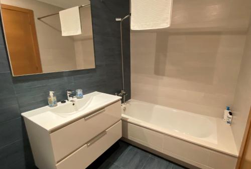 a bathroom with a sink and a tub and a mirror at A CUARTA RONDA in Melide