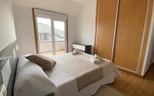 a bedroom with a bed with two towels on it at A CUARTA RONDA in Melide