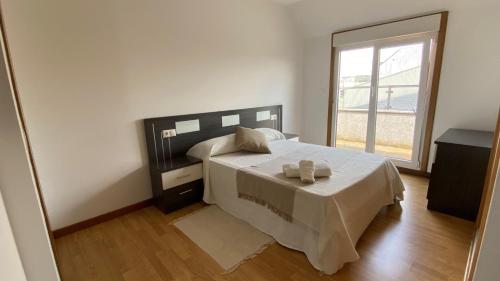 1 dormitorio con cama y ventana grande en A CUARTA RONDA, en Melide