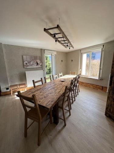 Cette grande chambre dispose d'une table et de chaises en bois. dans l'établissement Gîte des douze mulets, à Saulxures-sur-Moselotte