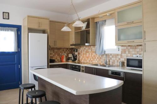 Ateni House في أجيوس بيتروس: مطبخ مع كونتر أبيض قمة وثلاجة