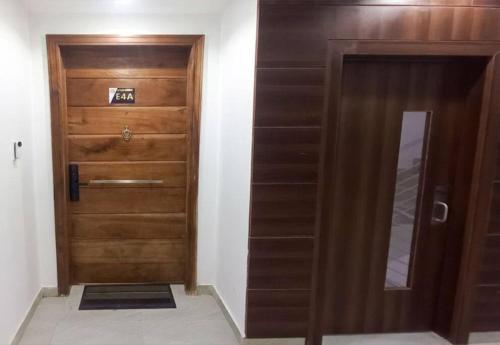 a wooden door in a room with a mirror at Westpark Luxury Apartments Smart Home inside Periwinkle Estate Lekki in Lekki