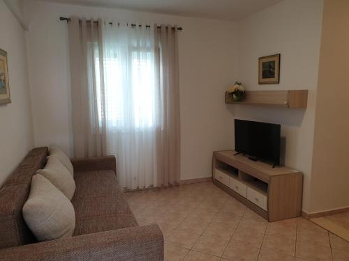 a living room with a couch and a flat screen tv at Seaview in Vrboska